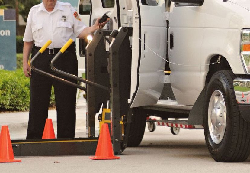 Accessible transportation van prepared for boarding with driver assistance in urban environment.